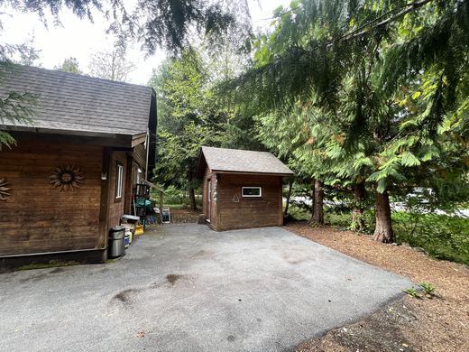 Private driveway with room for multiple vehicles, a trailer and sleds, alongside the storage shed