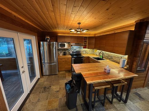Kitchen with butcher block counters, stone backsplash and stainless appliances