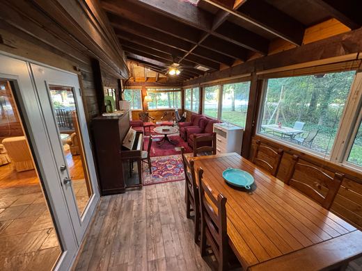 Sunroom dining area with the piano and doors through to the main house
