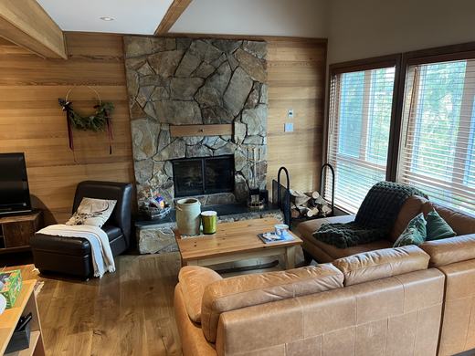 Stone fireplace and exposed beams in the Smoketree living room