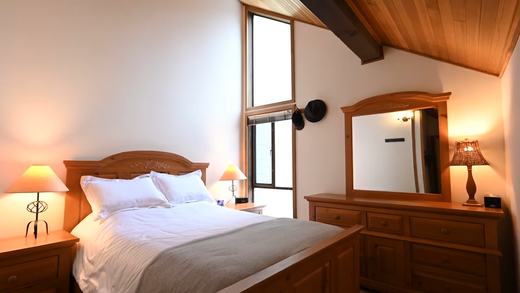Main bedroom with queen bed and high slanted ceiling
